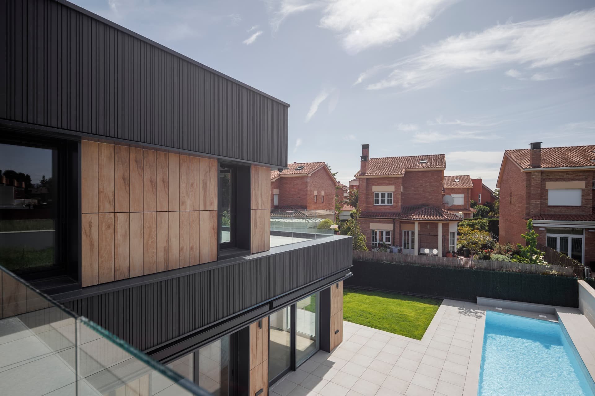 Vivienda unifamiliar de obra nueva con piscina, fachada de madera y metal negro